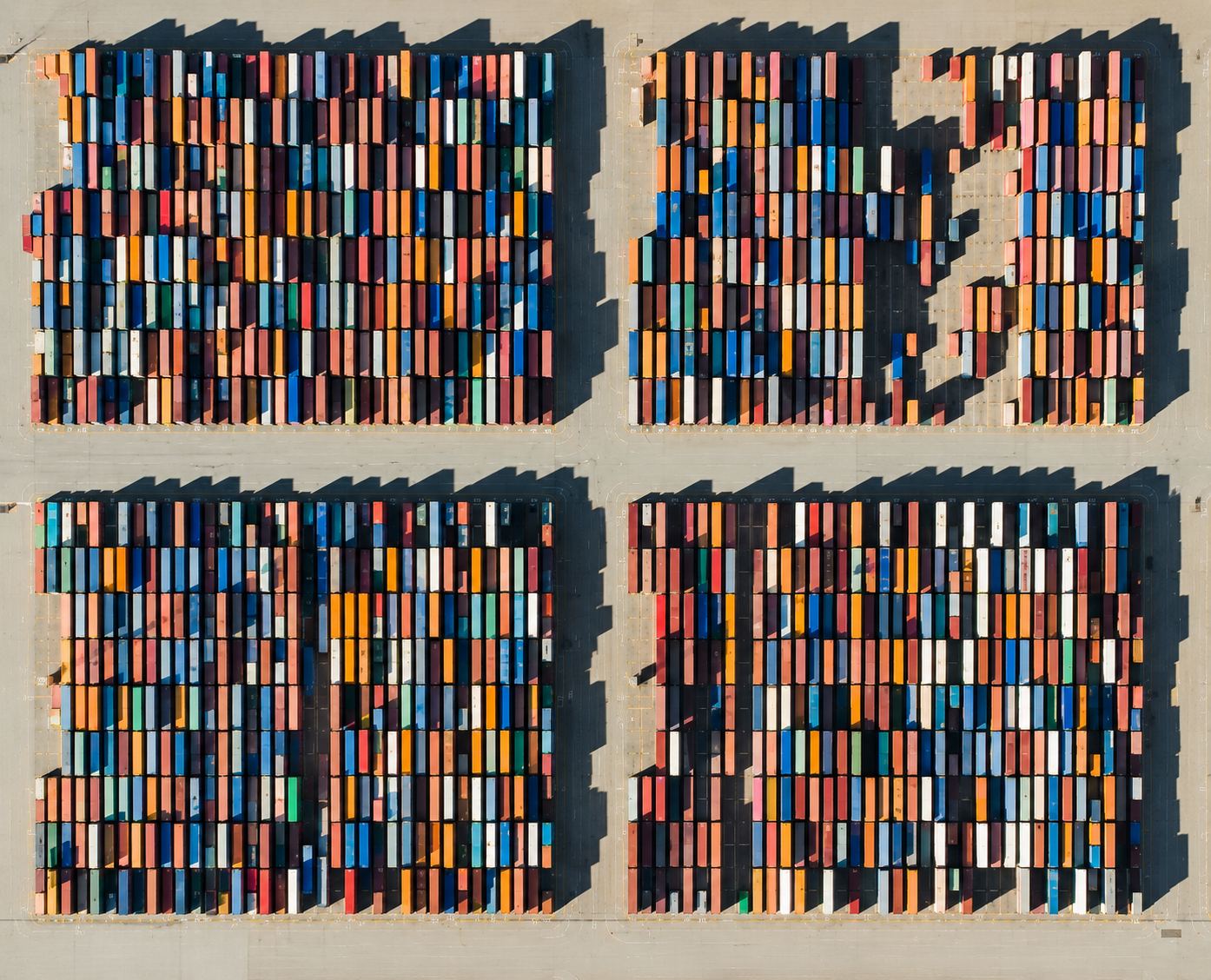 Aerial view of colorful shipping containers arranged in a global logistics yard